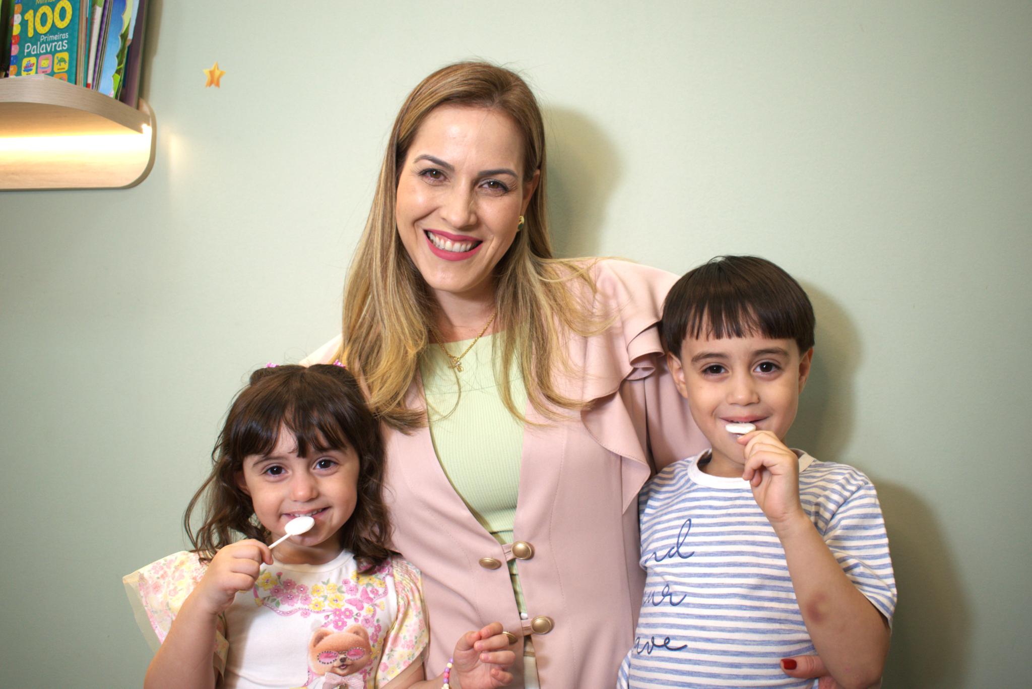 Dra. Lorena Soares com crianças, demonstrando a interação e o cuidado no atendimento de Processamento Auditivo Central (PAC) infantil.